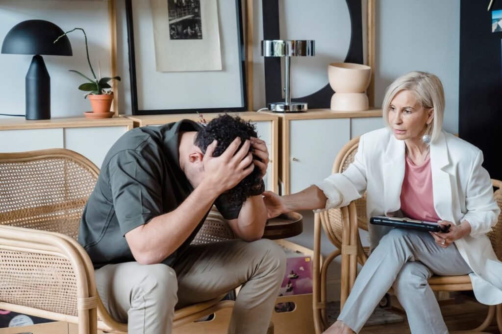 A supportive therapist provides comfort during a counseling session in a cozy office.